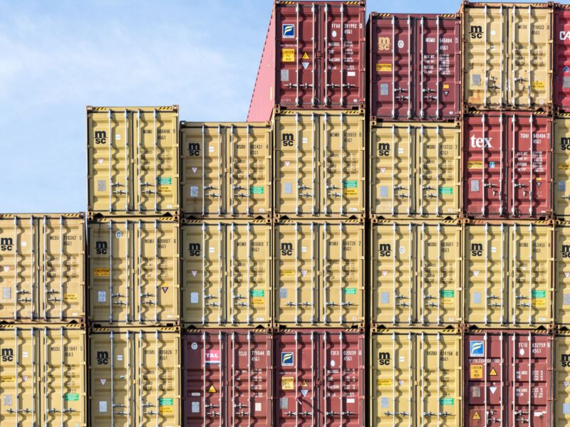Colorful stacked shipping containers at Hamburg port, showcasing global trade and logistics.